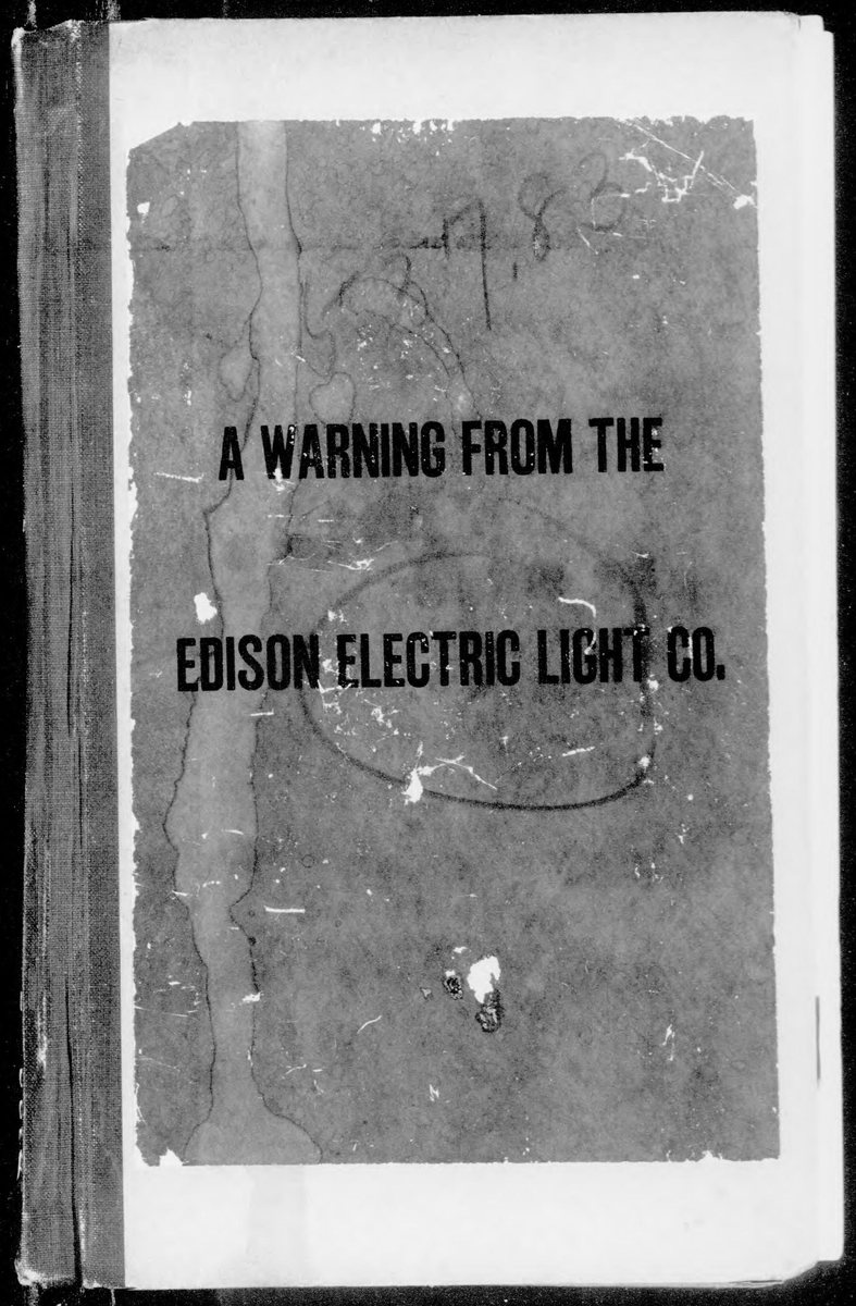 Photograph of a worn, stained pamphlet cover, bound at the left edge, printed in heavy black capitals: A Warning from the Edison Electric Light Co.