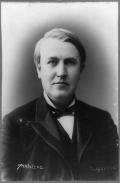 Black-and-white photograph of a heavy-set man with graying hair facing the camera, wearing a dark suit, a white shirt and a dark bow tie.