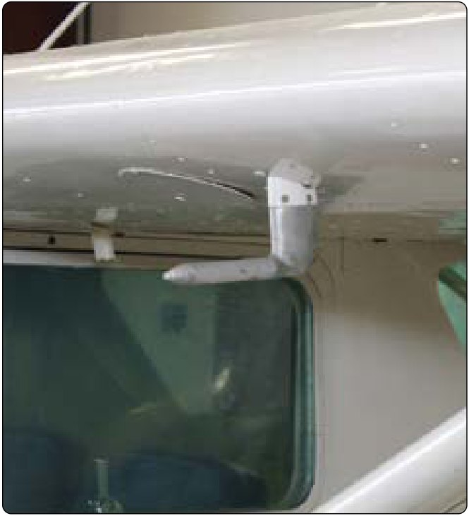 A pitot tube on a short mast under the white wing of a light airplane, pointing forward.